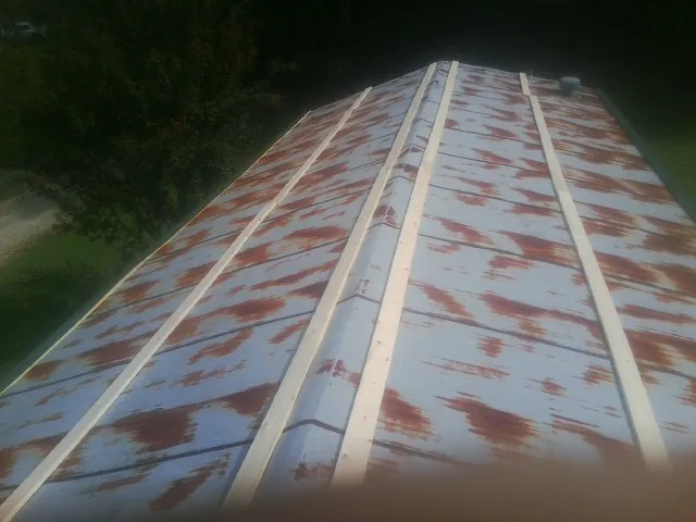 Rusted metal roof panels with new wood purlins before replacement — Storm Damage Roof Repair in North Versailles by Roofing Brothers